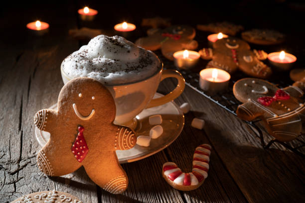 istock Gingerbread man Christmas cookies with hot chocolate mug candlelight 1281465002