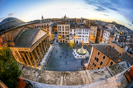 Rome, Italy -- A sunset light view from the rooftops of the iconic Piazza della Rotonda quarter, in the heart of Rome. At left the famous Pantheon with his dome and colonnade, one of the best preserved Roman structures in the Eternal City. The Pantheon was built in 27 b.C. by the Consul Marco Vispanio Agrippa for the emperor Augustus and dedicated to all Roman gods. Currently the Pantheon it is home to a Catholic church and inside there are the tombs of some Italian kings and the remains of the great Renaissance artist Raffaello Sanzio (Raphael). The fountain in the center of the square with an original Egyptian obelisk was built by the sculptor Leonardo Sormani in 1575 to a design by the architect Giacomo della Porta. Image un High Definition Format.