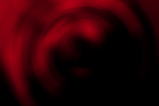 Blurred radial gradient dark red and black abstract background. Mixed circular texture