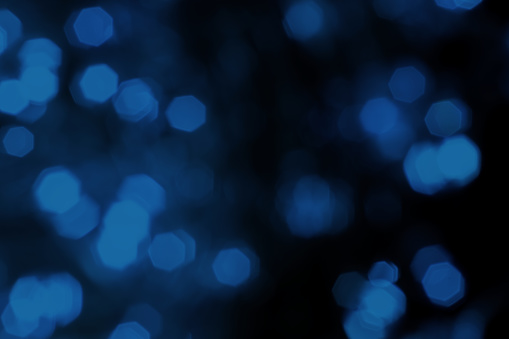 Blurred lights dark blue background. Abstract bokeh with soft light. Shiny festive Christmas texture
