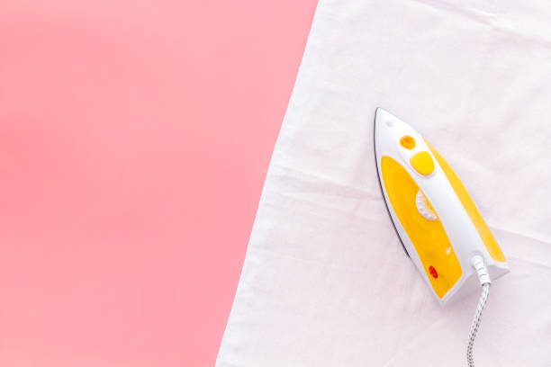 istock Iron with laundry clothes on ironing board. Above view 1281470855