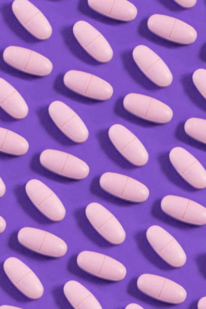 background medico - pill purple capsule vitamin pill foto e immagini stock