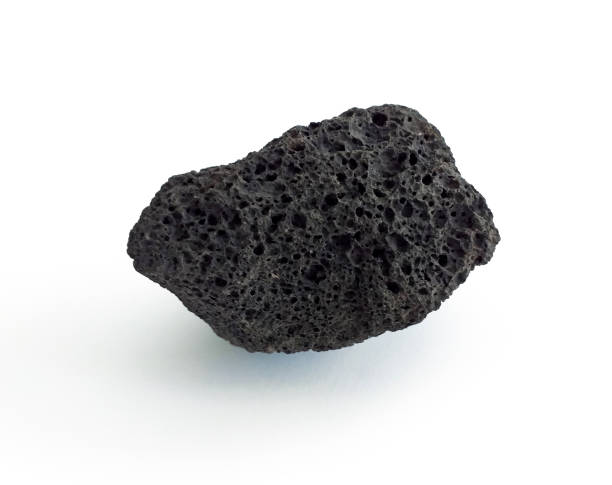 白い背景に隔離された多孔質の黒い火山岩。溶岩石、軽石、または白で隔離された独特の細孔を有する火山軽石。クローズアップ。 - volcanic stone ストックフォトと画像
