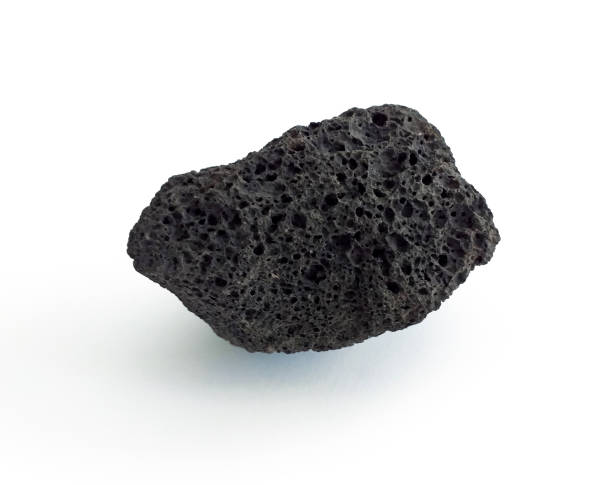 Porous black volcanic rock isolated on white background. Lava stone, pumice stone, or volcanic pumice with distinctive pores, isolated on white. Close up. Porous black volcanic rock isolated on white background. Lava stone, pumice stone, or volcanic pumice with distinctive pores, isolated on white. Close up. volcanic terrain stock pictures, royalty-free photos & images