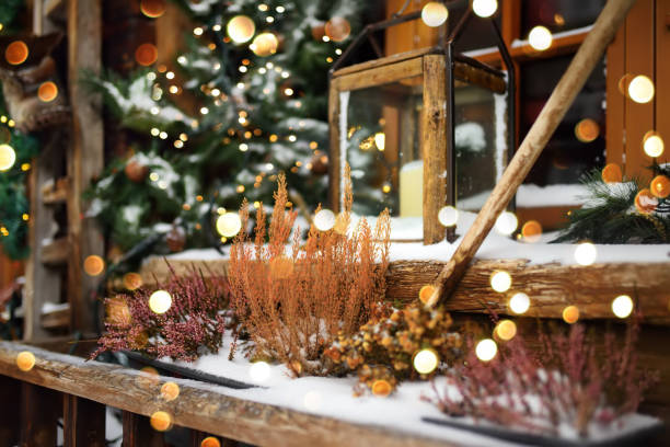 창 근처 세련된 크리스마스 장식 - 유럽의 작은 마을에서 거리에 큰 촛불이화 화환 조명과 등불이있는 전나무 가지. 겨울날의 축제 거리 장식과 조명 - switzerland snow winter swiss culture 뉴스 사진 이미지