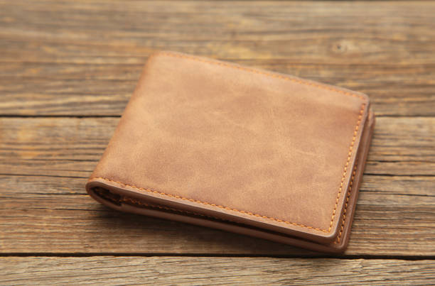 istock Brown shiny wallet on grey wooden background 1281477315