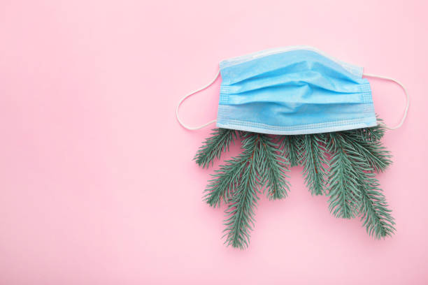 istock Coronavirus protective mask with fir-tree on pink. Covid-19 Christmas. 1281477341