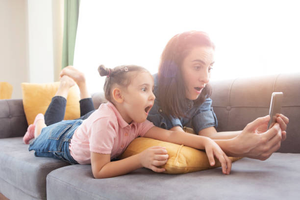istock Mother and daughter using phone 1281478349