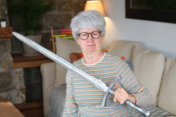 istock Senior geek holding a sword at home 1281479718