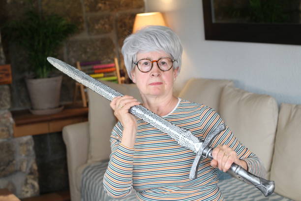istock Senior geek holding a sword at home 1281479721