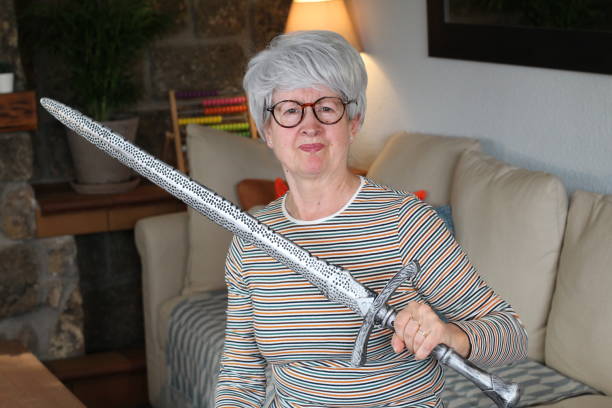 istock Senior geek holding a sword at home 1281479821