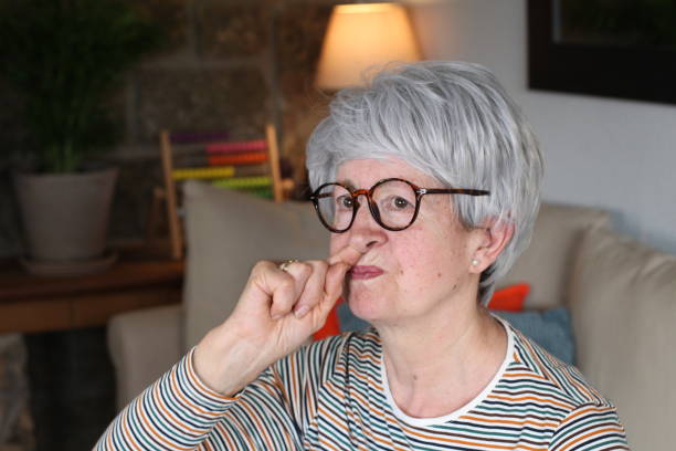 istock Senior woman picking her nose at home 1281479884