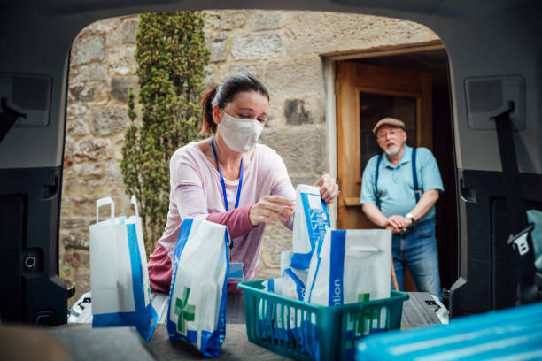 Pharmacist Delivering Medicine Pharmacist wearing protective face mask delivering medicine to a senior man during the Covid 19 pandemic. frontline worker mask stock pictures, royalty-free photos & images