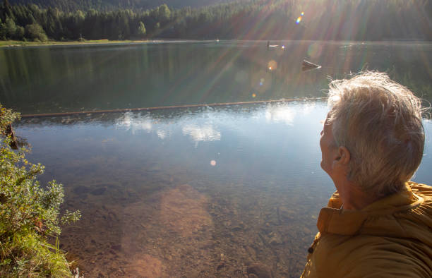 istock Man relaxes by lakeshore at sunrise 1281480075