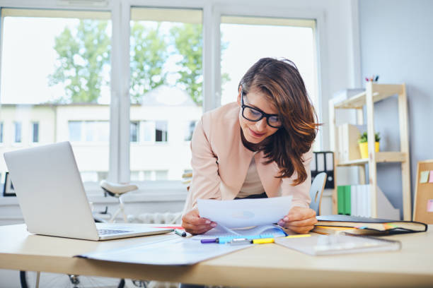 istock Busy woman working in small office reading documents 1281481291