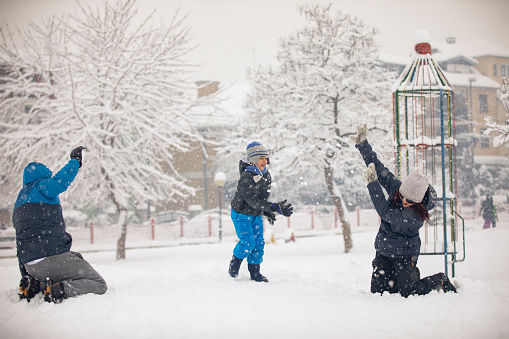 Happy family enjoying time together and play on snow