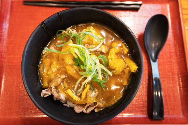 istock Japanese curry rice with beef in a black bowl on table with nature light through the window. 1281485253