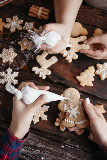 istock Friends decorating Christmas gingerbread cookies 1281487676