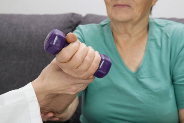 istock Therapist assisting senior woman with exercises. Elderly patient using dumbbells in the physical therapy session. Rehabilitation health care concept. 1281487957