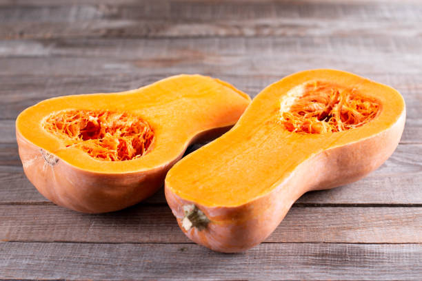 istock Pumpkin, butternut squash pieces on wooden background, closeup. Cooking winter squash 1281488089