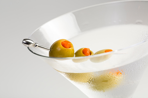 vodka or gin martini cocktail with fresh green olive garnish