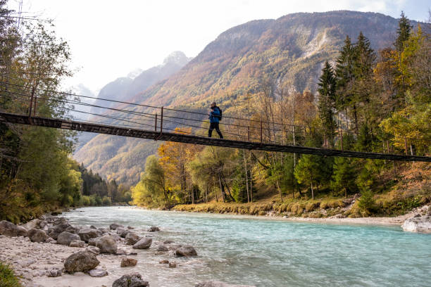 senior man walking on the suspension bridge over the soa river - slowenien stock-fotos und bilder