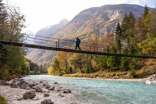 Senior Man walking on the Suspension bridge over the Soča River
