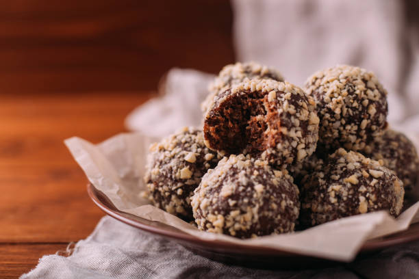 palline di cacao, torte al tartufo al cioccolato a bordo su sfondo legnoso - choco foto e immagini stock