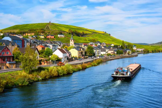 Moselle river by Wormeldange, Luxembourg country, with vineyard hills and a cargo barge ship