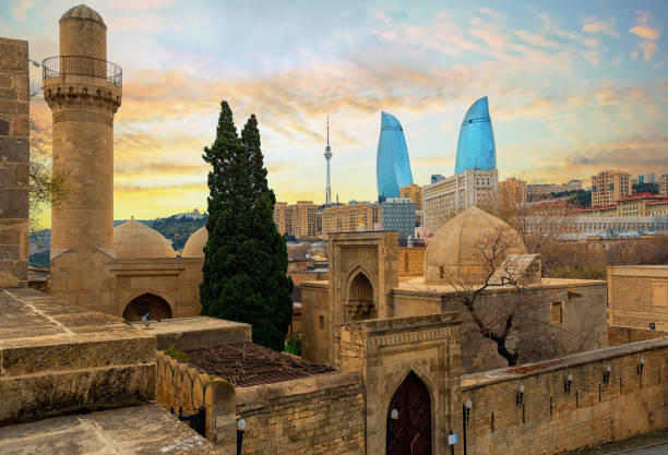 Old and modern architecture in Baku city, Azerbaijan Baku city, Azerbaijan, view of the historical mosques and the walls of Shirvanshahs palace in the Old town and modern glass Flower Towers skyscrapers in dramatic sunset light baku photos stock pictures, royalty-free photos & images