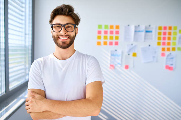 Casual young man standing in startup office