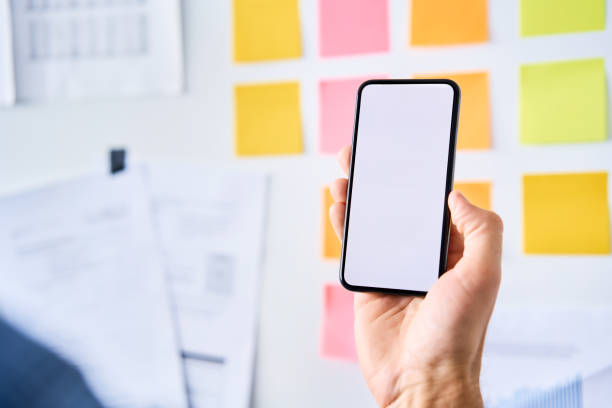 istock Closeup of man holding smartphone at startup office 1281494091