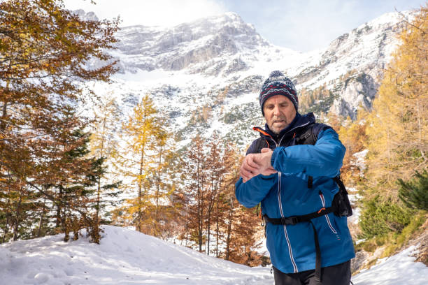 Photo of Senior man checking his smart watch high up in the Alps