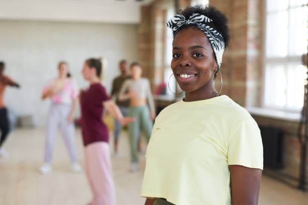 African dancer at sport club Portrait of young African woman smiling at camera while training in dance studio dance studio instructor stock pictures, royalty-free photos & images