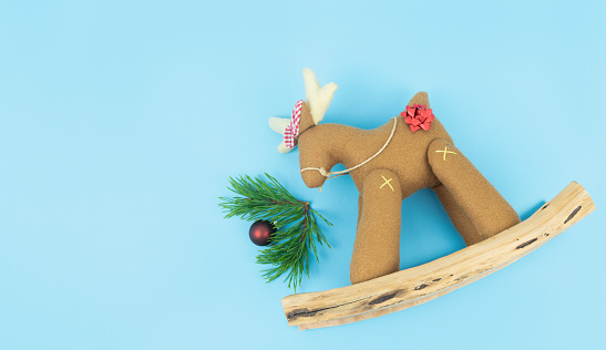 Decorative Christmas reindeer with pine branches on a blue background. Copy space.