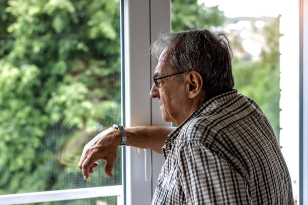 istock Elderly man looking outside the window. 1281499649
