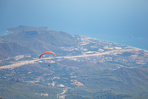 Paraglider flying over mount Tahtali in Turkey, Kemer. Paragliding in the mountains