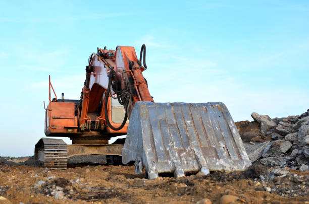 istock Excavator with a large iron bucket breaks asphalt on a construction site 1281504071