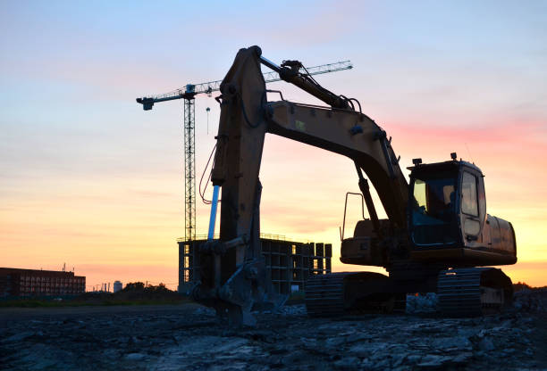 istock Large tracked excavator with hydraulic shears on a construction site against the background of the awesome sunset 1281504077