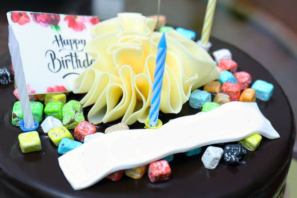 istock Birthday chocolate cake with colorful candles 1281505783