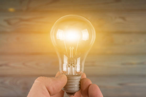 istock Creative idea, burning light bulb in the hand of a businessman. 1281505812