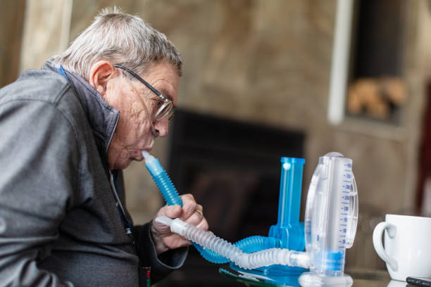 istock Senior man using disposable spirometers to exercise his lungs in order to keep his alveoli inflated in a sufficient manner, so he can breathe better. 1281506078