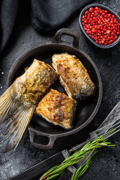 istock Roasted piece of silver carp. Black background. Top view 1281506975