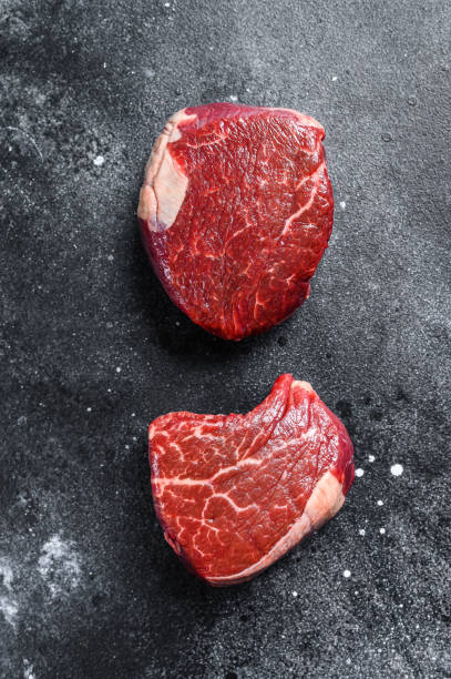 istock Raw beef meat steak Tenderloin fillet. Black background. Top view 1281507531