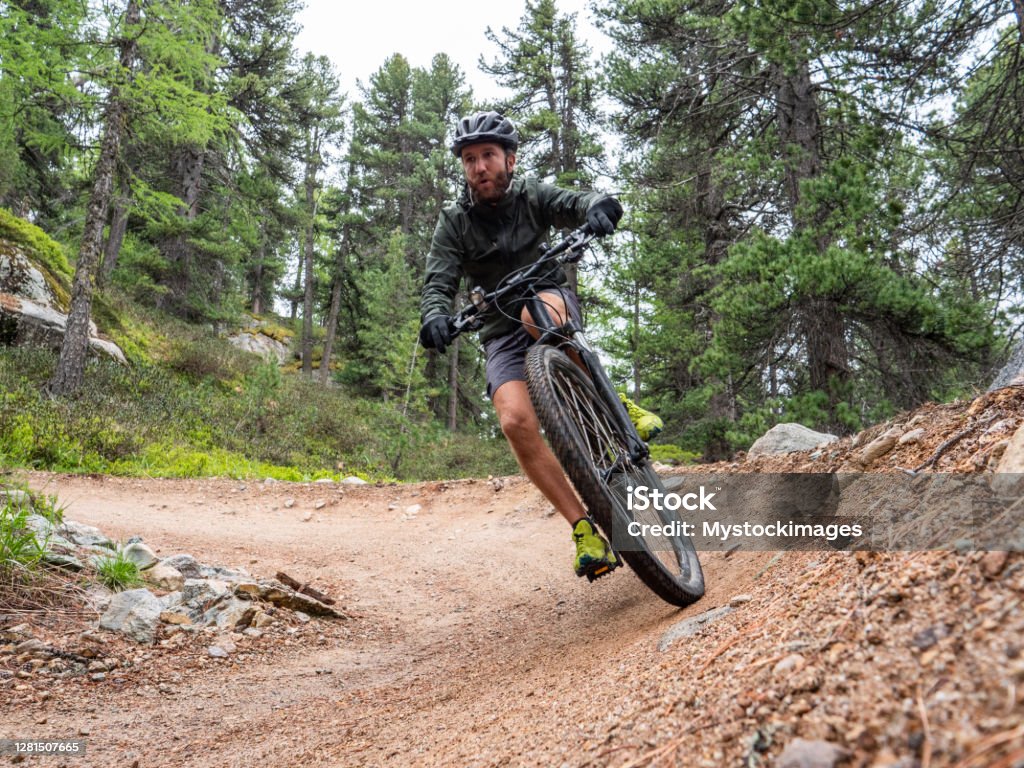 Mountain biker on flow trail, Switzerland Man on mountain bike passing on flow trail Electric Bicycle Stock Photo
