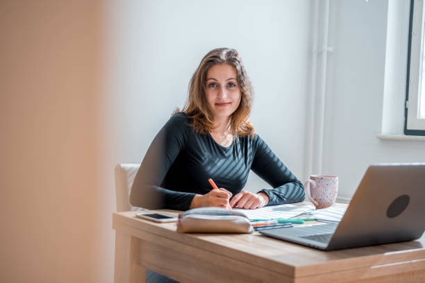istock Caucasian Female Student Learning At Home Using Laptop And Looking At Camera 1281507714