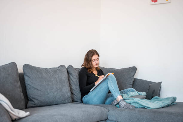 istock Young Woman Sitting On Sofa And Studying 1281507720