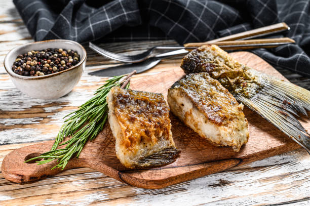 istock Grilled river fish silver carp on a cutting board. Wooden background. Top view. 1281508617