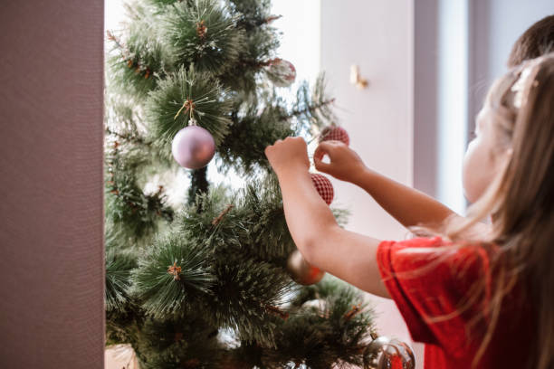 istock Girl decorating Christmas tree at home. 1281510787