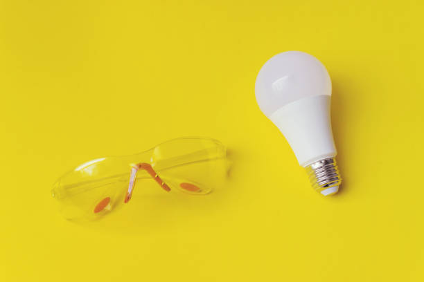 istock White light bulb and Builder's safety glasses Against Yellow Background. 1281514100